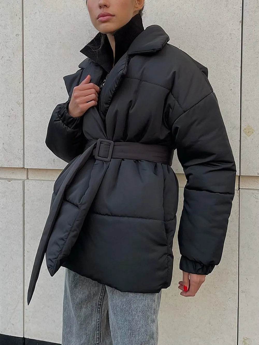 Model wearing a black puffer long sleeve winter coat with belt, featuring a stylish, basic design.