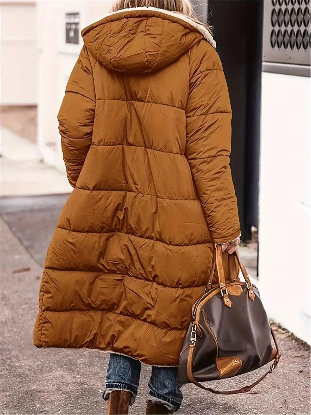 Woman wearing a full size zip up sherpa hooded coat in brown with a stylish handbag.