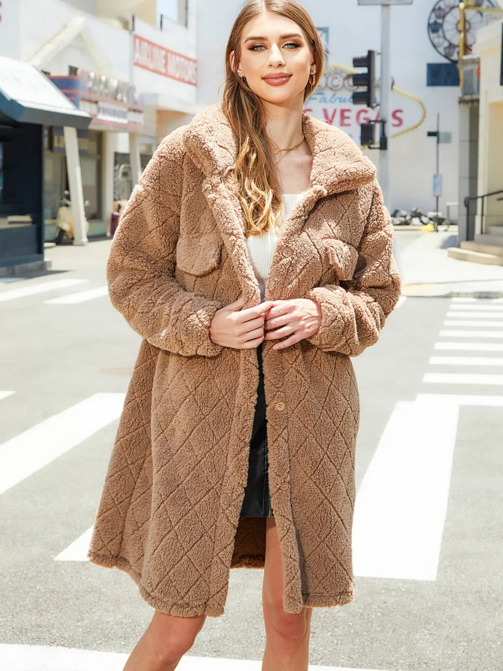 Model wearing a texture button-up dropped shoulder coat in a light brown shade, on an urban street setting.