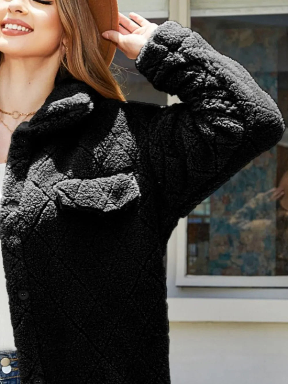 Model wearing a black texture button-up dropped shoulder coat with pocket detail and cozy design.