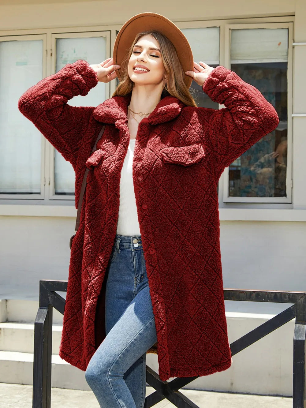 Model wearing a cozy texture button-up red coat with pockets and a hat, showcasing a stylish relaxed look.