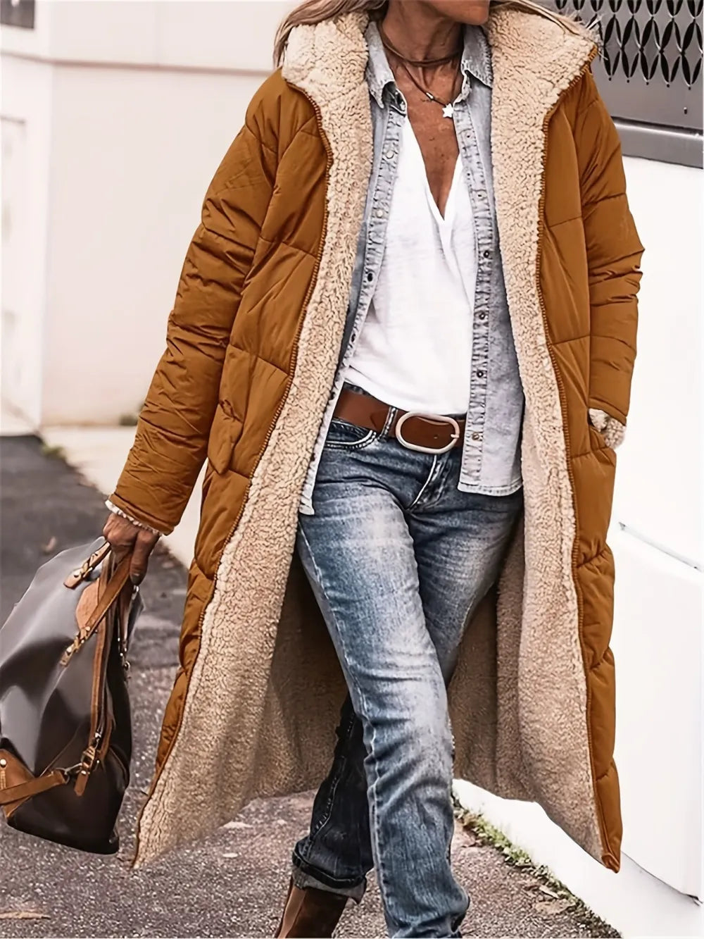 Woman wearing a full size zip up sherpa hooded coat in brown, styled with jeans and a shirt.