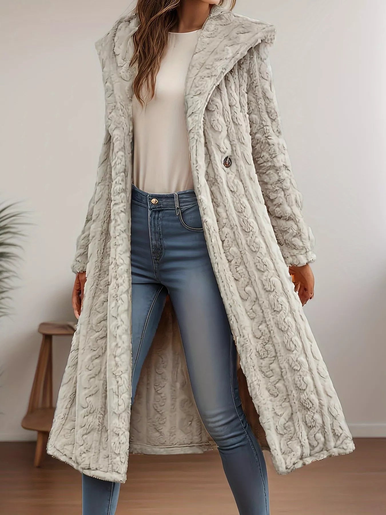 Sherpa longline hooded coat in light gray, featuring a buttoned front and cable knit texture, worn with blue jeans.