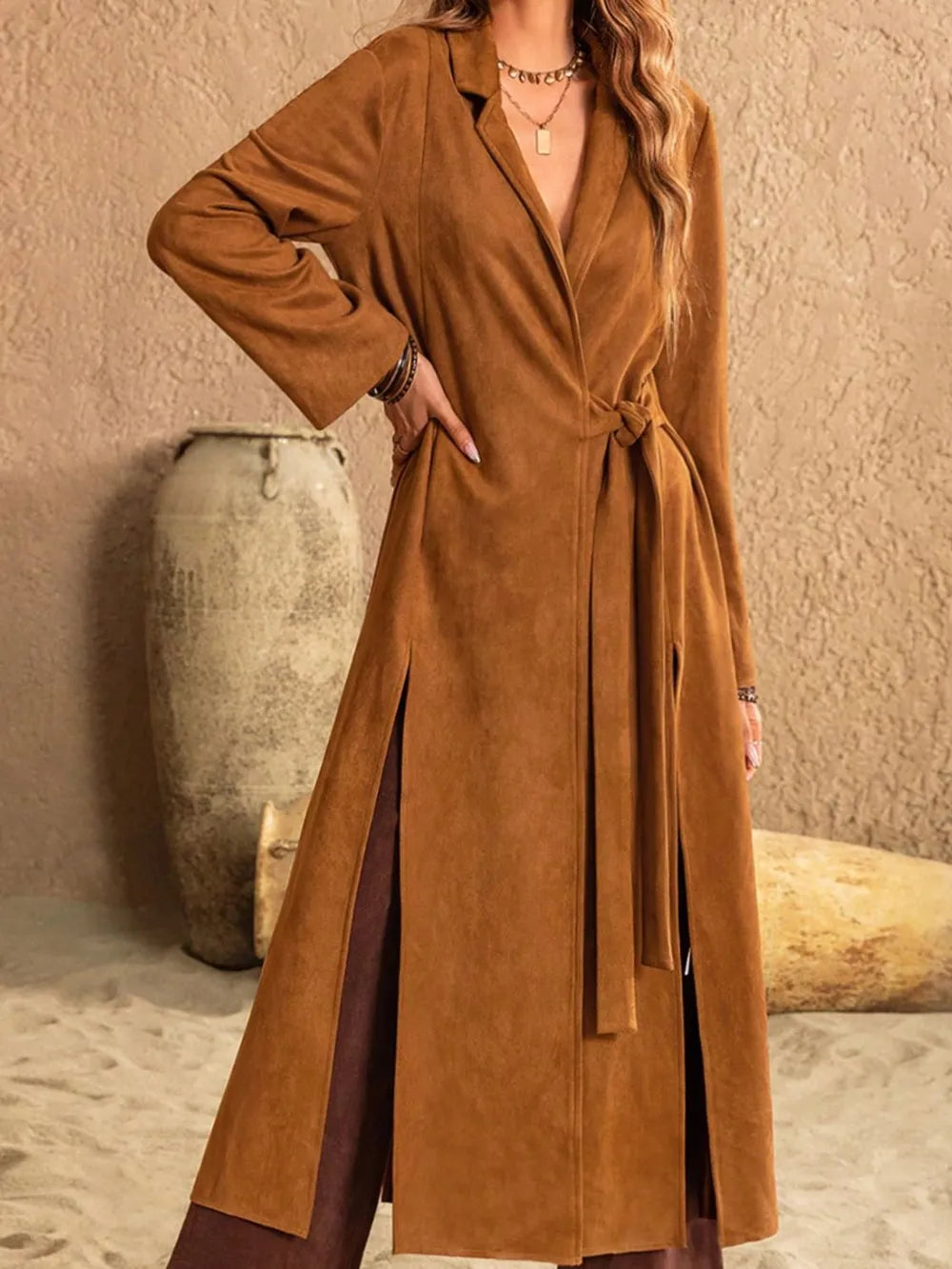 Slit tied collared neck longline coat in warm brown with side slits and belt, styled for a chic look.