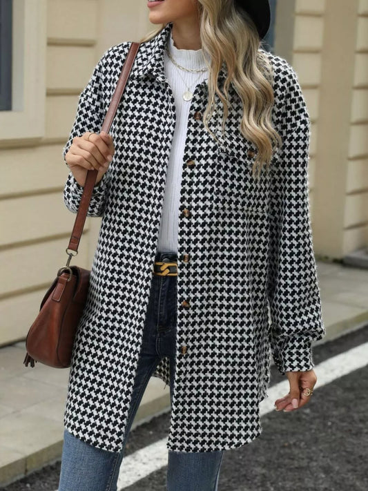 Woman wearing a houndstooth button-up long sleeve coat with a white sweater and jeans, holding a brown handbag.